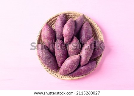 Purple sweet potatoes in basket on pink background, Top view Royalty-Free Stock Photo #2115260027