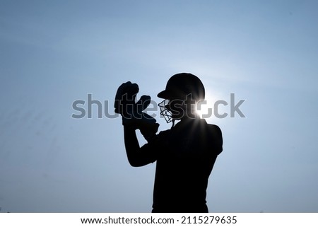 Silhouette of a cricket player getting ready before the match in the evening. Indian cricket and sports concept. Royalty-Free Stock Photo #2115279635