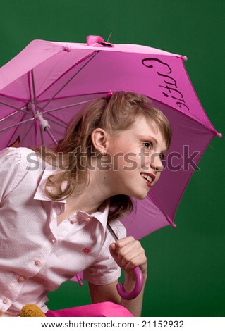 Young girl with umbrella on green background