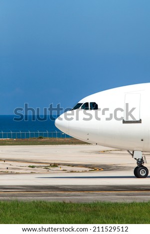 head of a plane at the airport near the beach and sea