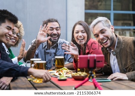 Group of young friends make Video Call in outdoors bar. Beautiful Young Diversity People drinking beer