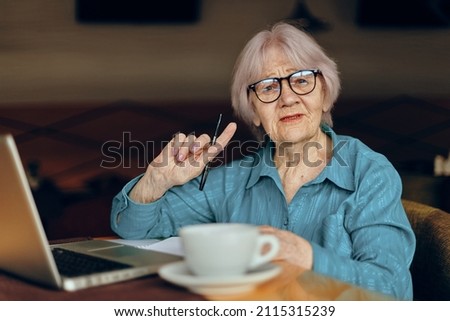 Portrait of an elderly woman documents work sheet of paper and pen Retired woman chatting unaltered