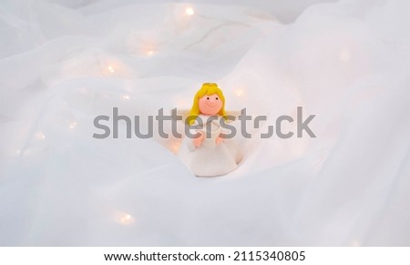 Cute angel on a white background. A positive emotion. beautiful still life with a toy fairy on a light background. spring season. the concept of celebrating Valentine's Day or Mother's Day, birthday.