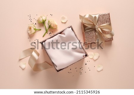 Open gift box, confetti and roses on pink background, flat lay. Royalty-Free Stock Photo #2115345926