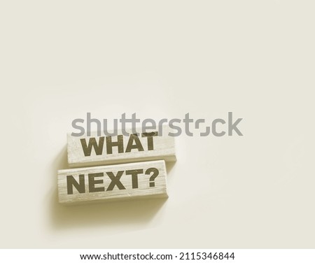 The words What Next on wooden blocks, close up shot, view from above. Next steps concept for business or medicare