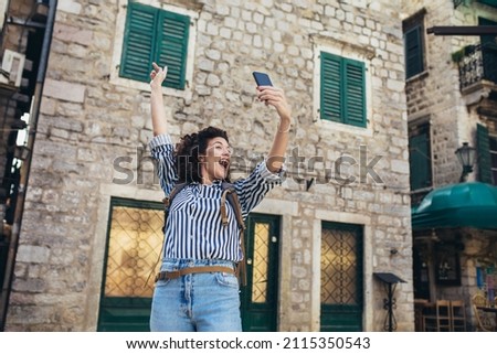 Woman tourist walking on the street and make selfie photo.
