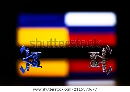Conceptual image of war between Russia and Ukraine using toy soldiers and national flags on a reflective background Royalty-Free Stock Photo #2115390677