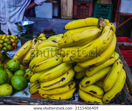 Close up of bunch of fresh yellow ripe organic Banana, kept on wooden hand cart in the fruit market for sale at Kolhapur, Maharashtra, India. focus on object. no people.
