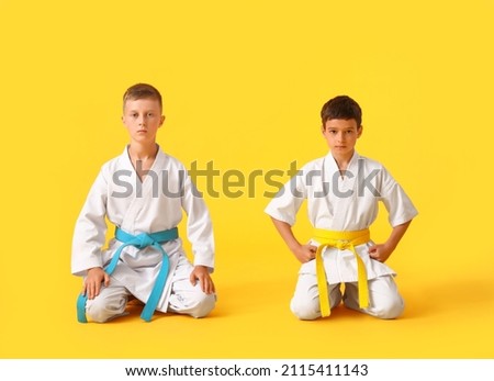 Little boys in karategi on color background Royalty-Free Stock Photo #2115411143