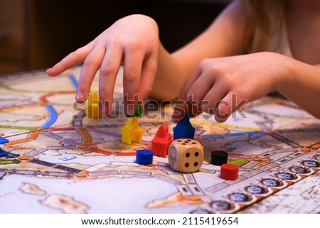 the child's hands hold colored chips on the playing field, board games, a game cube