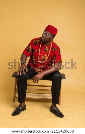 Igbo Traditionally Dressed Business Man Sitting Down and Posturing