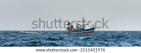 Small fishing boat sailing in an open Mediterranean sea, close-up. A view from the yacht. Leisure activity, sport and recreation, food industry, traditional craft, environmental damage concepts Royalty-Free Stock Photo #2115421976