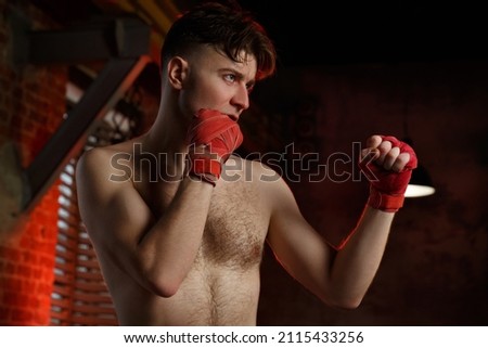 A male boxer is training in the gym.