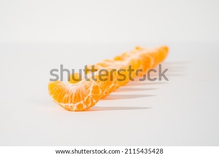 pieces of orange line up in the line isolated on white background. shallow depth of field. studio lighting.