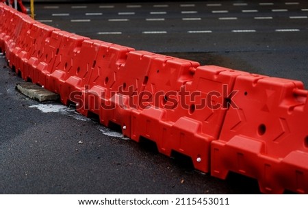 Red platypus barriers along the street. blocking traffic on the road. 