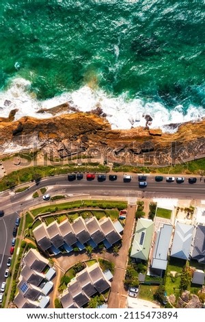 Vertical aerial view over Pacific ocean coast waterfront on Sydney north shore with strata title villas by seaside. Royalty-Free Stock Photo #2115473894