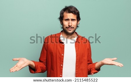 young handsome indian man feeling clueless and confused, not sure which choice or option to pick, wondering Royalty-Free Stock Photo #2115485522