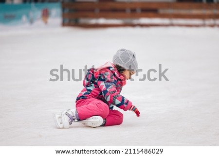 Lovely little girl, getting up after falling on ice while skating.
