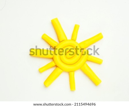 On a white background, a yellow sun made of plasticine
