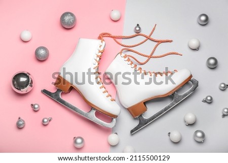 Ice skates and Christmas balls on color background