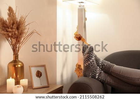 Woman in warm socks lying on sofa at home