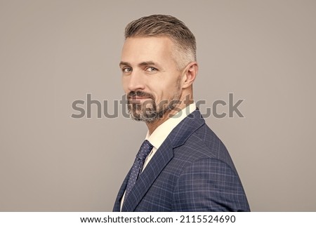 mature ambitious man businessman in businesslike suit has grizzled hair, success portrait