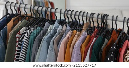 Rack with stylish clothes indoors, banner design. Fast fashion