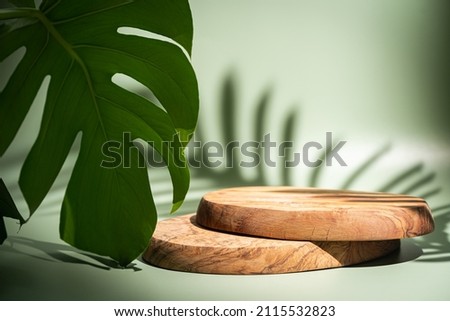 Wooden podium with leaves and shadows. Realistic wood platform for product presentation. Minimal nature scene with pedestal mockup. cosmetic display or award ceremony Royalty-Free Stock Photo #2115532823
