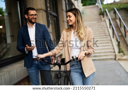 Young businesswoman and businessman standing on the street Beautiful businesswoman with bicycle.	