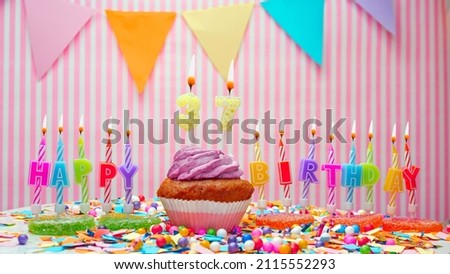Happy birthday number 37. On a pink background, congratulations on the birthday of a thirty-seven-year-old. Muffins with pink cream with a burning candle. Copy space