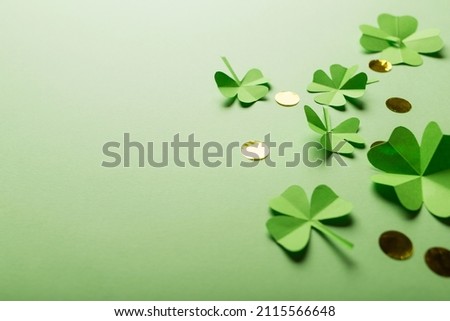 St. patrick's day. green background with clover leaves: shamrock and four-leafed, coin or confetti. copy space. Paper craft.