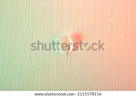 Gradient from green to beige color background with one fallen white cherry flower petal. Easter holiday card with neon light. Boy or girl. Art. Minimalist style. Heart is love symbol. Purity concept