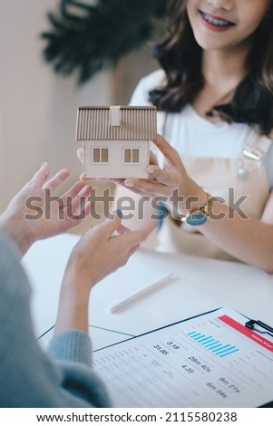 Close up of Business woman giving house after signing agreement for buying house. Bank manager and real estate concept.
