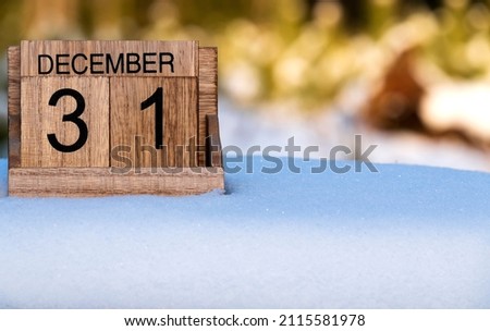 Wooden calendar of December 31 date standing in the snow in nature.