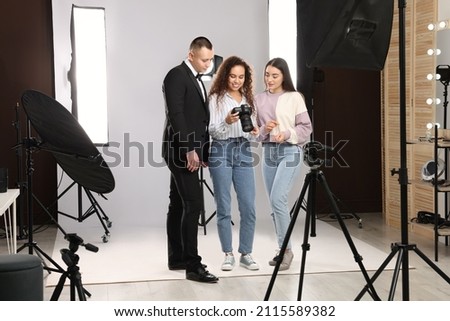 Professional photographer and makeup artist with model in studio