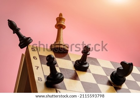 The black chess pieces attack the white queen on the edge of the chessboard. Concept of competitive career struggle. Royalty-Free Stock Photo #2115593798