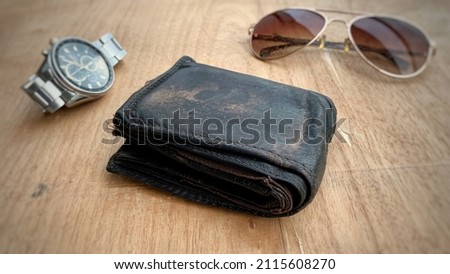 Old leather wallet on top of brown table. 