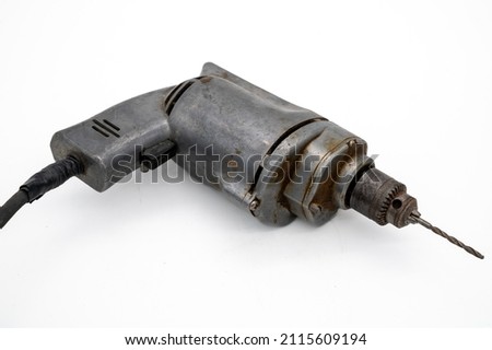 Vintage Electric Drill Showcased With A White Background. A solid metal vintage corded electric drill with drill bit ready for use. Royalty-Free Stock Photo #2115609194