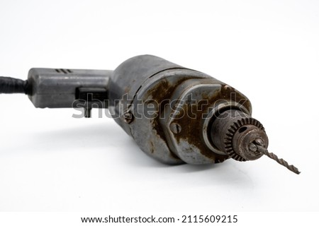 Vintage Electric Drill Showcased With A White Background. A solid metal vintage corded electric drill with drill bit ready for use. Royalty-Free Stock Photo #2115609215
