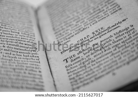 An Old English Book Is Opened To A Section Of The Novel Revealing Slightly Discolored Pages And Ancient English Writing. Royalty-Free Stock Photo #2115627017