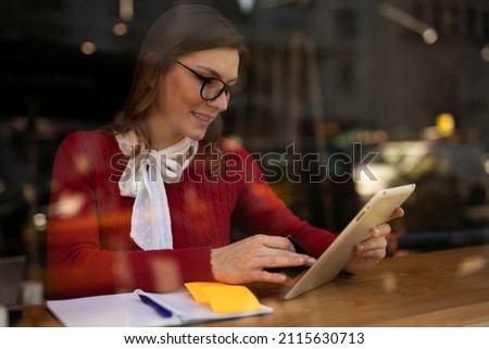 Happy woman using credit card to shopping online with tablet. Beautiful young woman drinking coffee in cafe.	