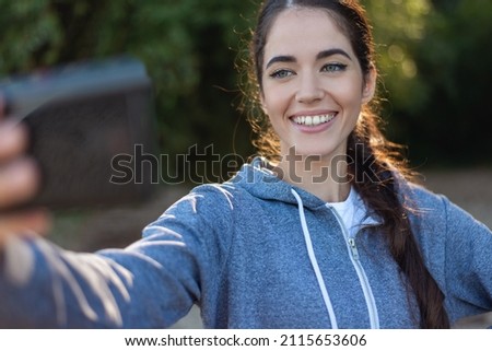 Beautiful woman taking selfie on mobile phone on blurred background