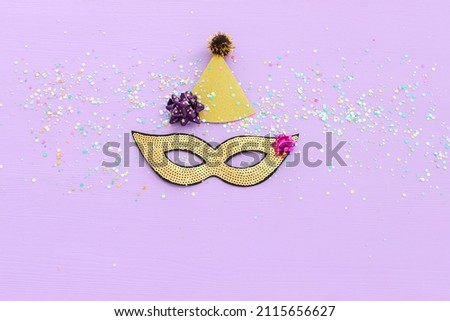 Holidays image of mardi gras masquarade sequins mask over purple background. view from above