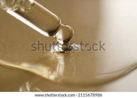 Pipettes with oil or serum on a golden background. Royalty-Free Stock Photo #2115678986