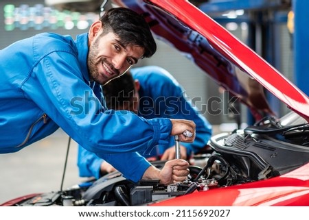 Happy smile Caucasian automobile mechanic man checking car damage broken part  condition, diagnostic and repairing vehicle at garage automotive, motor technician maintenance after service concept Royalty-Free Stock Photo #2115692027
