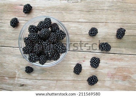 Blackberries in the bowl on the wooden table