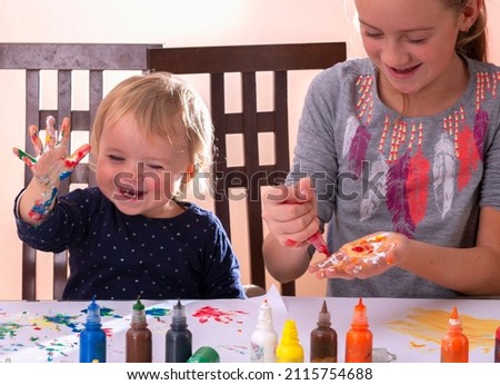Art lessons for all aged children. Happy children with painted hands drawing pictures. Concept: carefree happy childhood, learning art and creativity. 