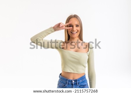 Happy beautiful young woman showing peace sign with both hands over white background