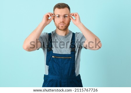 Portrait of a friendly worker. Isolated on blue