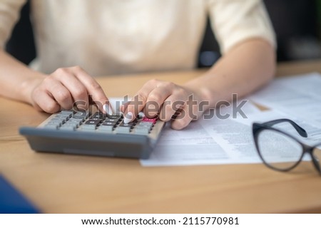 Experienced accountant making financial calculations on the calculating device